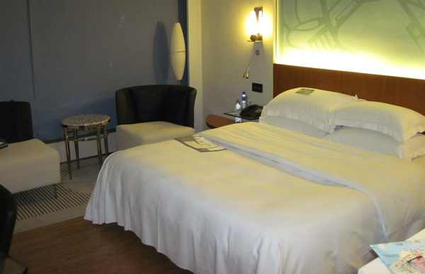 a hotel room with a bed and chair