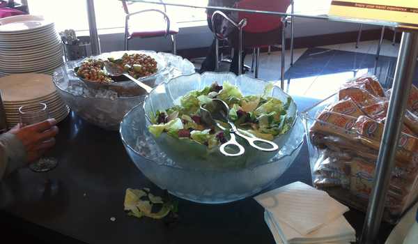 a salad bowl with scissors and a bowl of food
