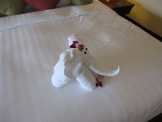 a towel elephant made of flowers on a bed