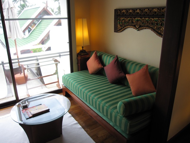 a green couch with pillows in a room