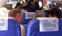 people sitting on an airplane with a group of people