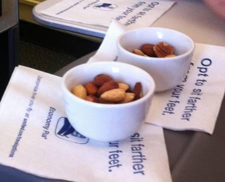 a couple of white bowls with nuts