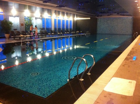 a swimming pool with people standing in the background