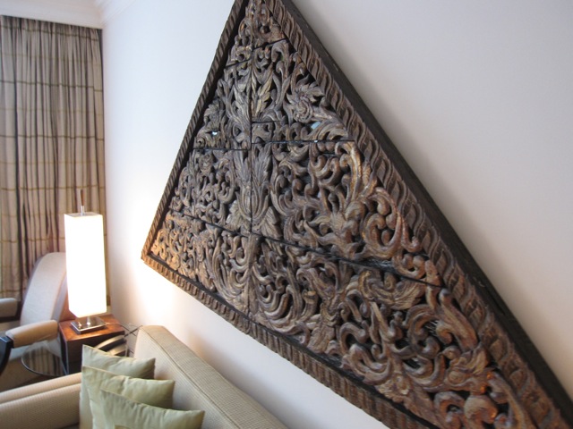 a triangular wooden art piece on a wall