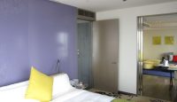 a bedroom with a purple wall and a bed
