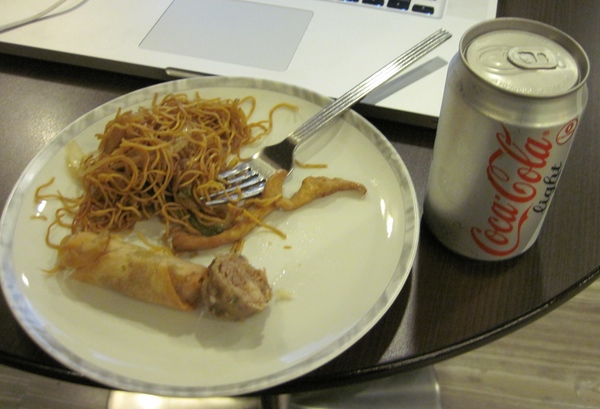 a plate of food and a soda can