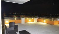 a patio with chairs and a view of the city from the roof