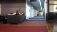 a woman sitting on a couch in a hallway