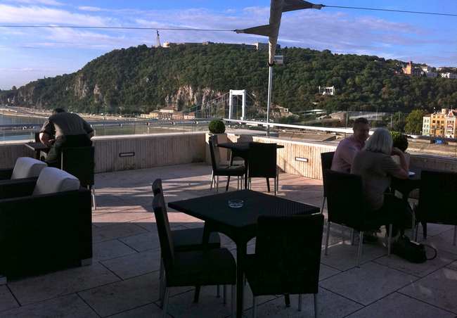 a group of people sitting at tables on a patio