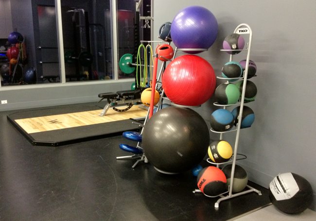 a group of balls and a rack of exercise equipment