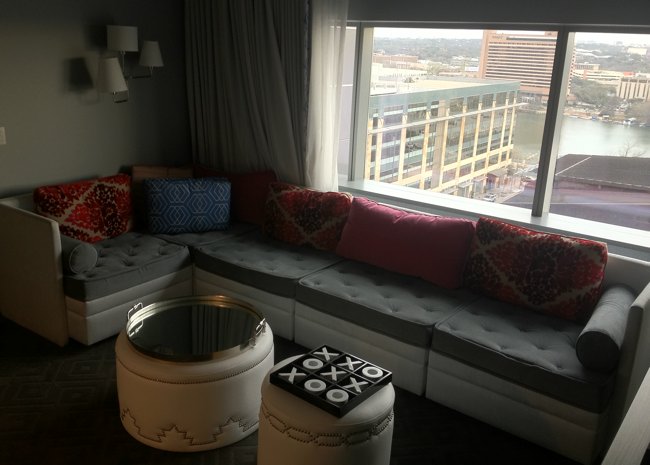 a couch with pillows in a room with a large window
