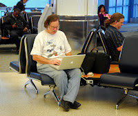 a man sitting in a chair using a laptop