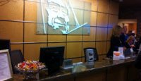 a reception desk with computer monitors and a sign on the wall