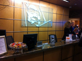 a reception desk with computer monitors and a sign on the wall