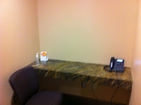 a desk with a telephone and a chair
