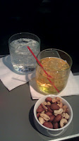 a glass of liquid and a bowl of nuts
