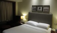 a bed with white sheets and pillows