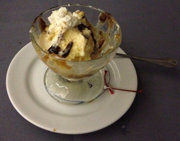 a bowl of ice cream with a spoon on a plate