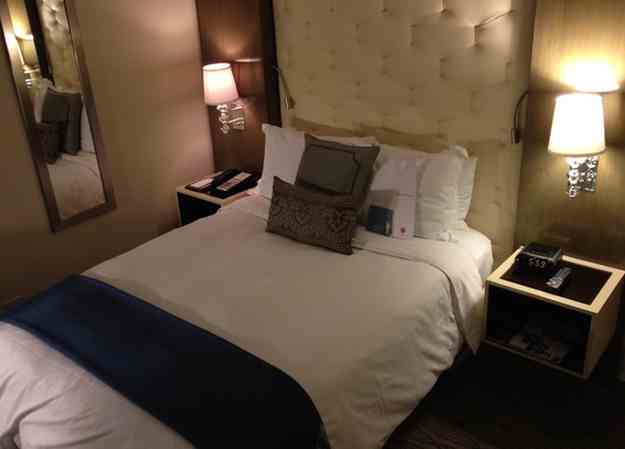 a bed with pillows and a mirror
