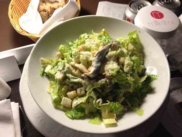 a plate of salad with anchovies and cheese