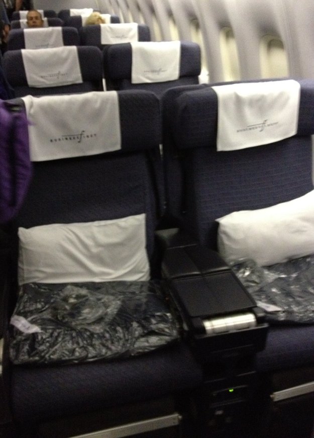 a seat with white pillows and a black arm rest