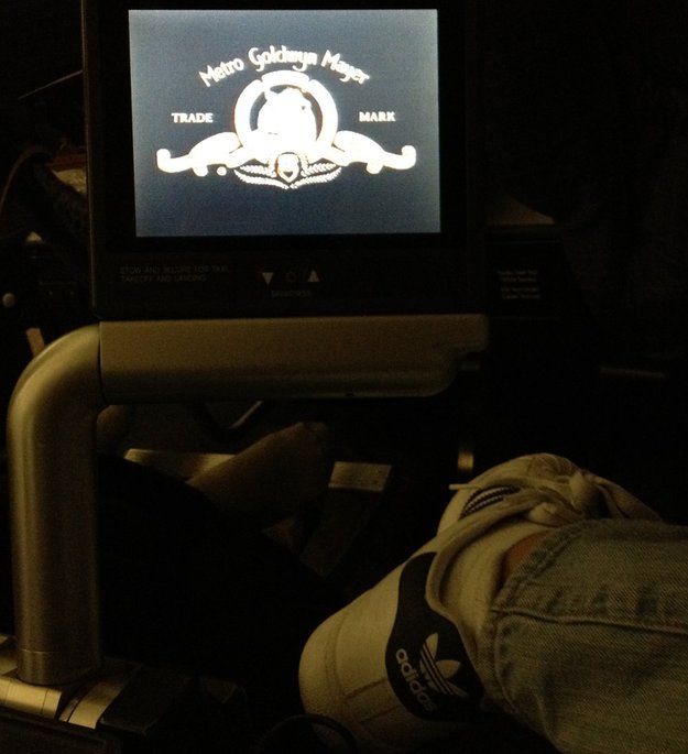 a person's feet in a dark room with a tv screen