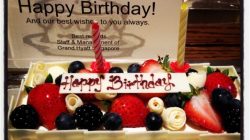 a birthday cake with fruit and candle