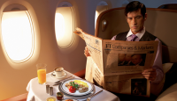 a man reading a newspaper on an airplane