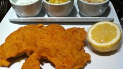 a plate of fried fish and side dishes