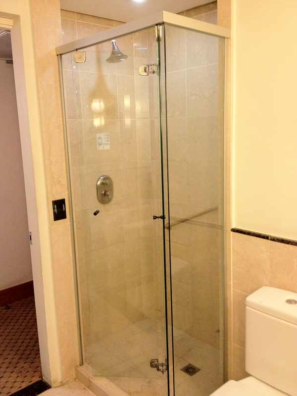 a glass shower with a toilet