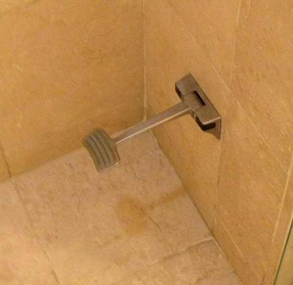 a metal foot rest in a shower