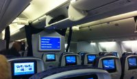 a row of seats with monitors on the back
