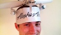 a man wearing a hat with a model airplane on his head