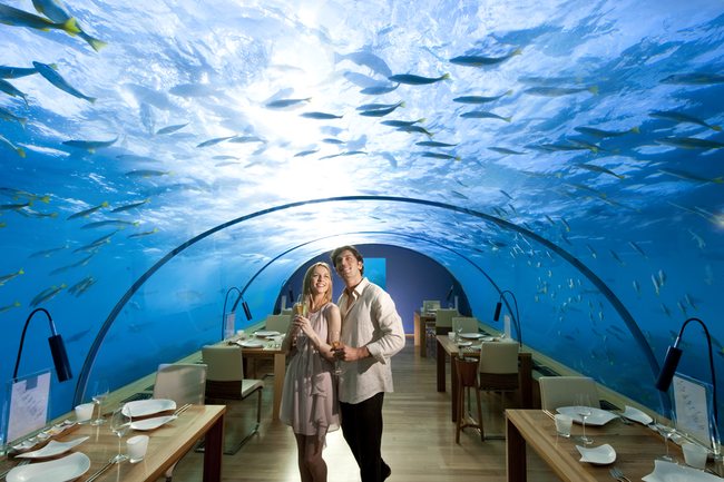a man and woman holding hands in a restaurant