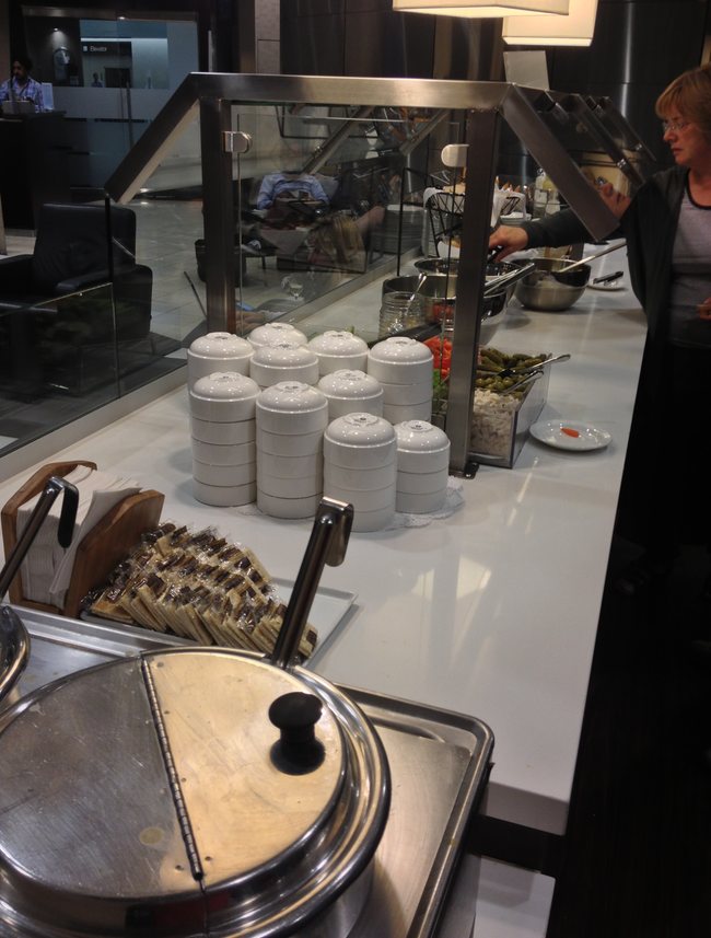 a woman standing behind a counter with white containers