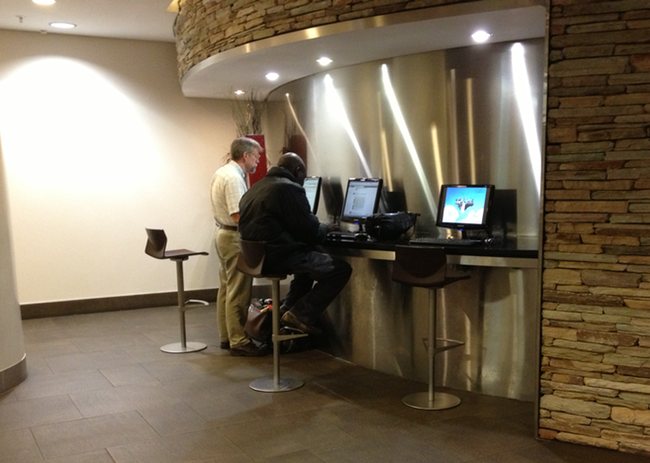 a group of men sitting at a counter with computers