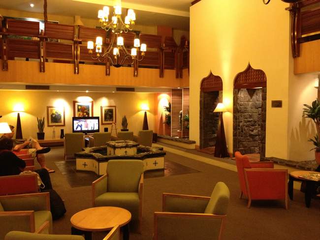 a room with a large living room with a large fireplace and a large chandelier