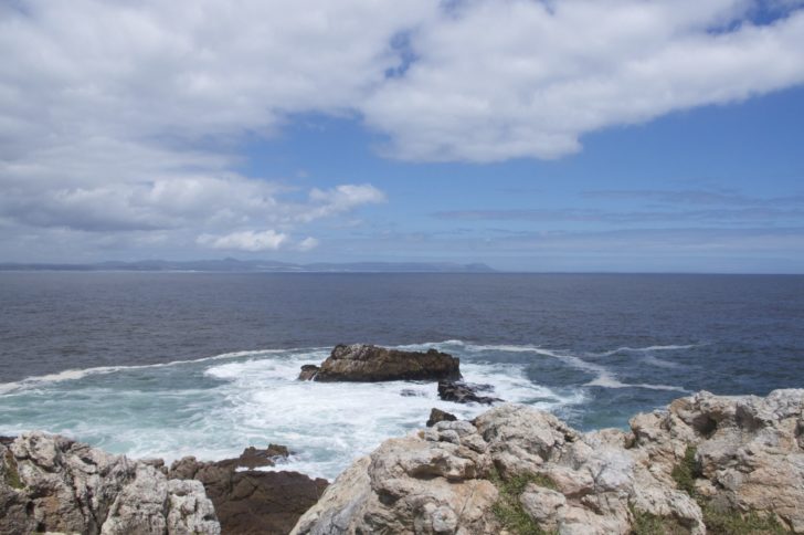 a rocky shore with waves crashing on the rocks