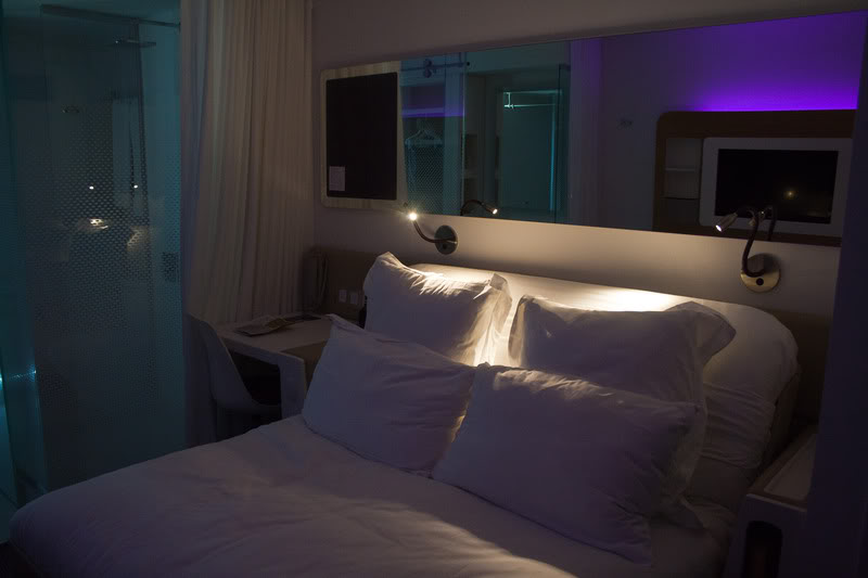 a bed with pillows and a mirror above it