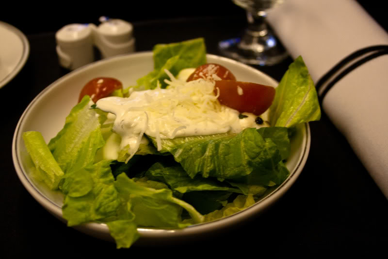 a bowl of salad with cheese and tomatoes