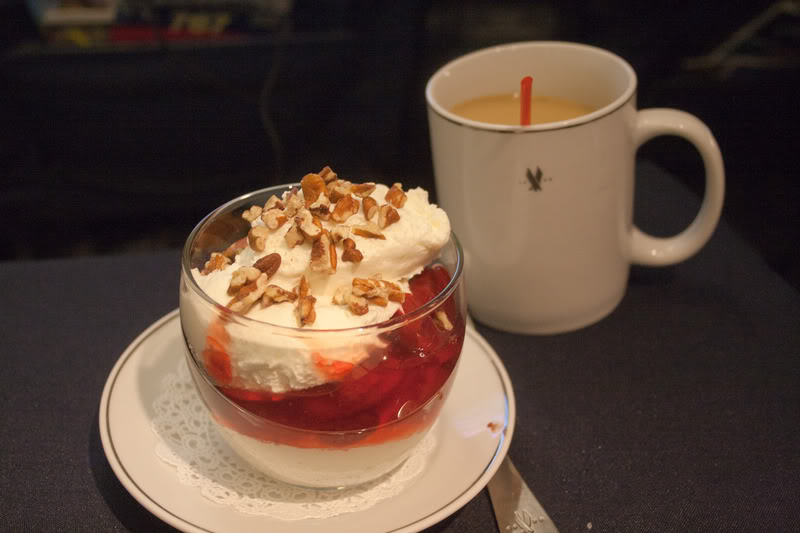 a dessert on a plate next to a cup of coffee