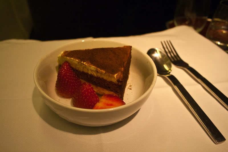 a plate of dessert with strawberries and a spoon