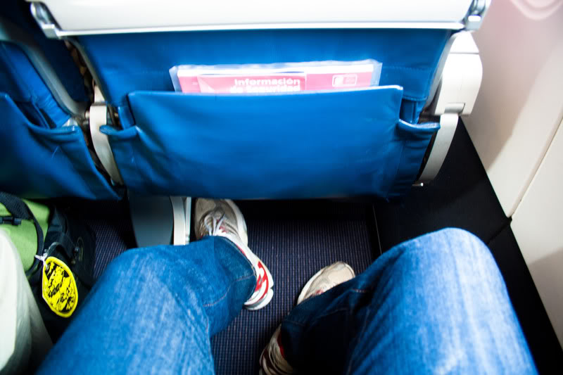 a person's legs and a pocket in a seat