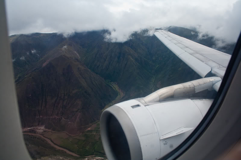 a view of a plane wing and mountains from a window