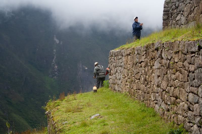 a group of people standing on a stone wall