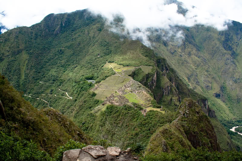a green mountain with a stone structure