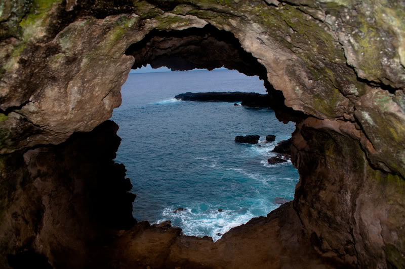 a view from a cave of the ocean through a hole