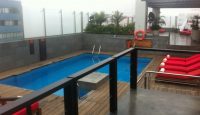 a pool with red chairs and a deck