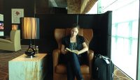a woman sitting in a chair reading a book