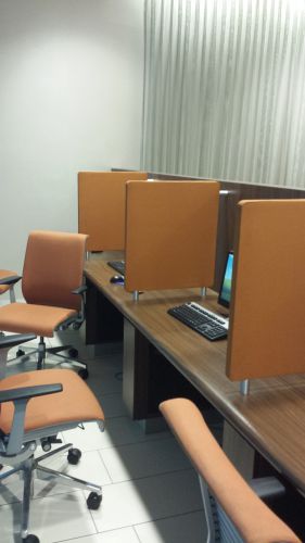 a desk with chairs and computer screens